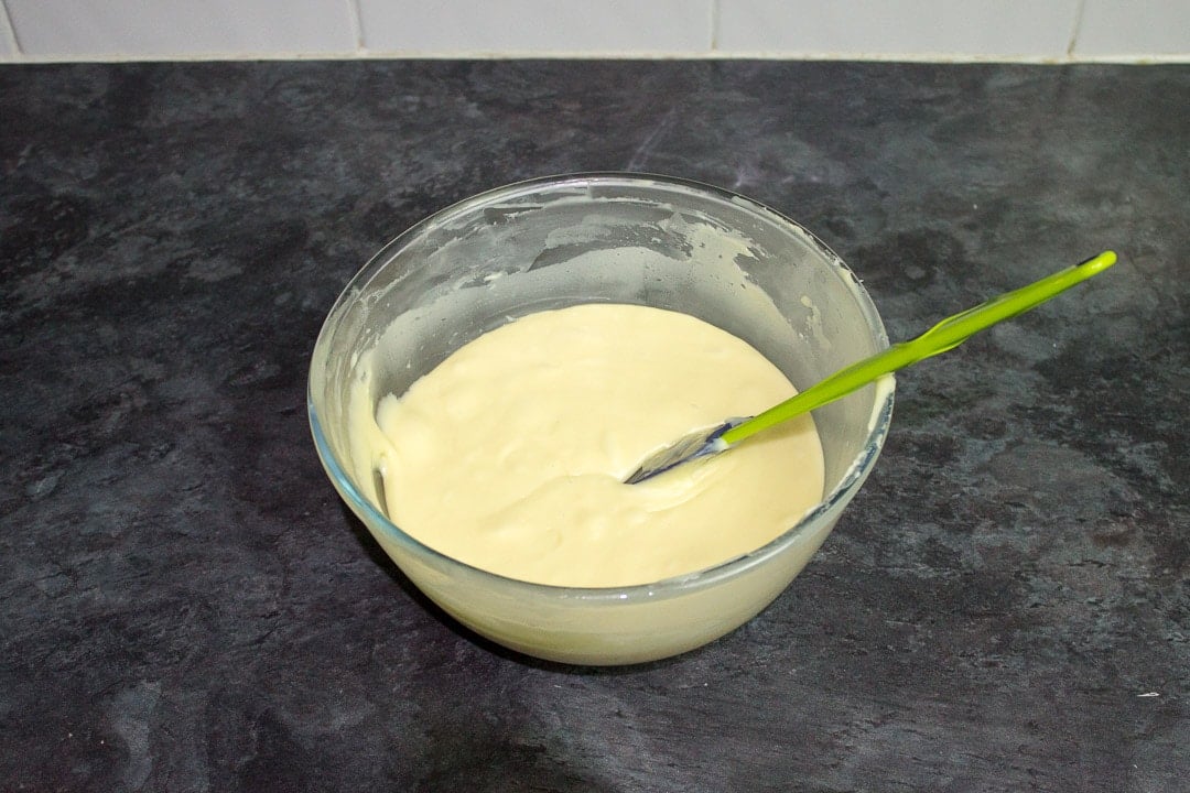 melted white chocolate, butter, condensed milk and vanilla in a glass bowl
