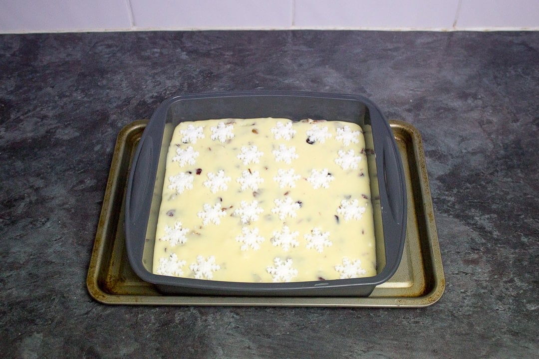 white chocolate pecan cranberry fudge in a silicone pan with fondant snowflakes on top