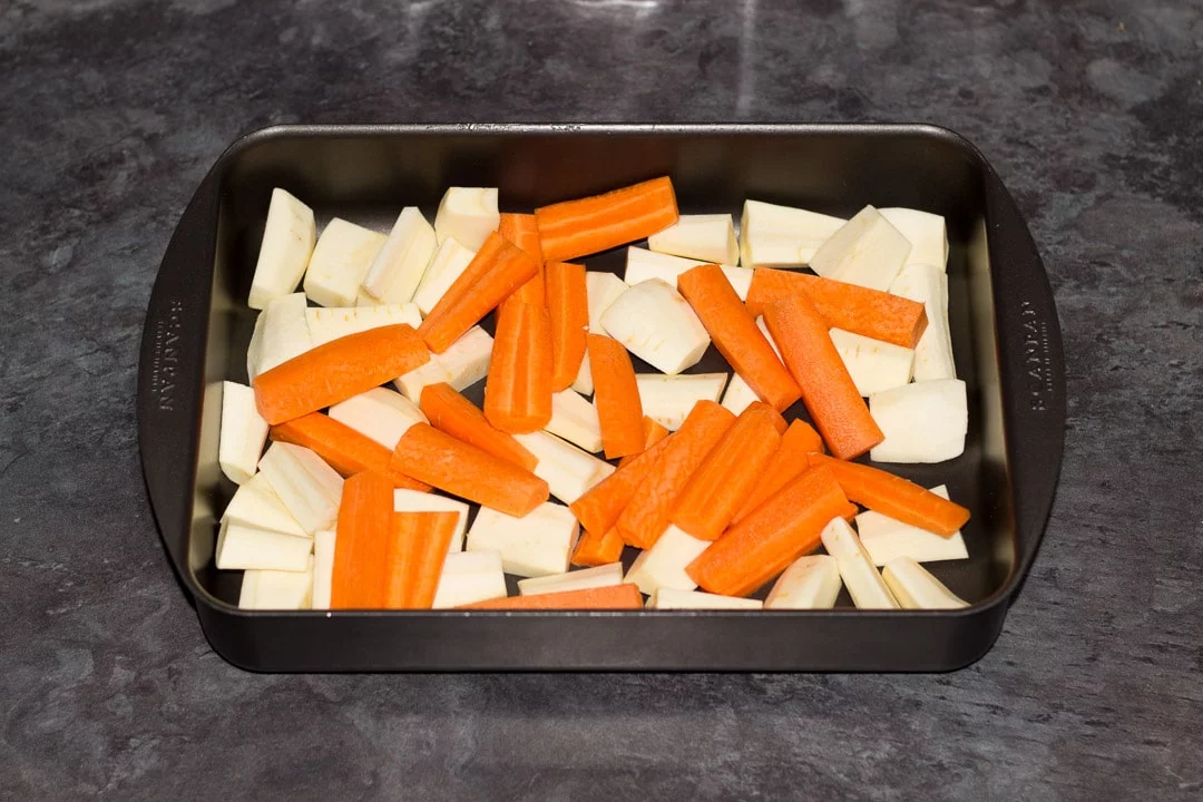 carrots, parsnips and rosemary in a roasting dish