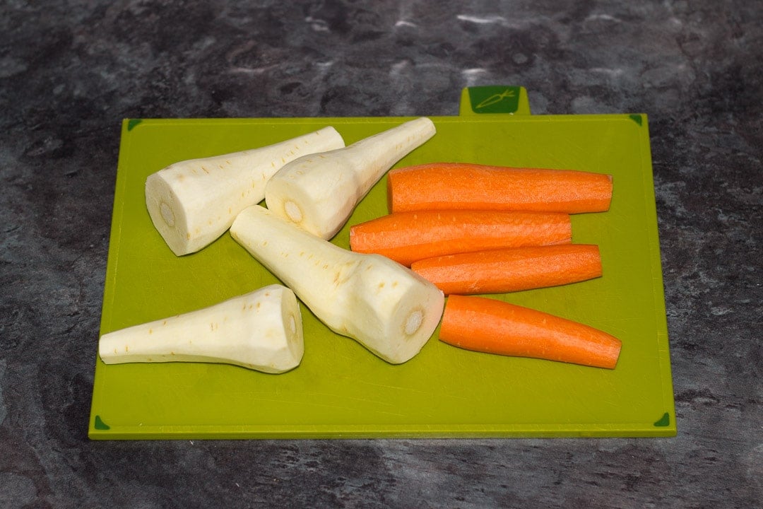 peeled carrots and parsnips on a chopping board
