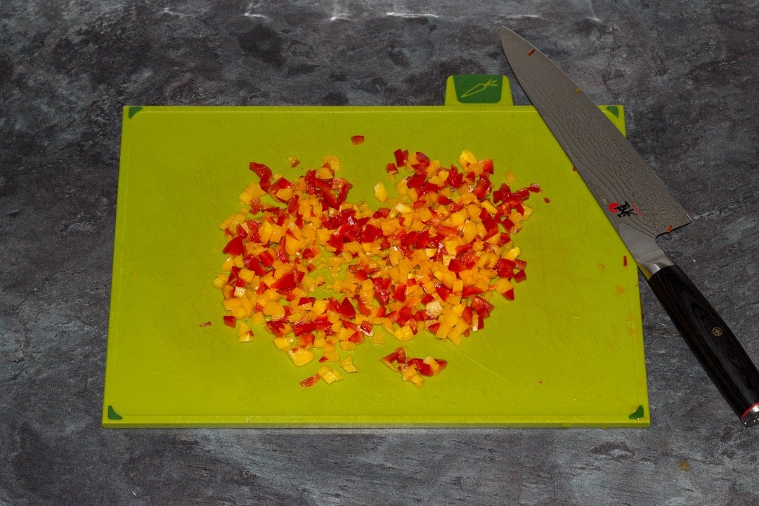 red and yellow peppers finely chopped on a chopping board