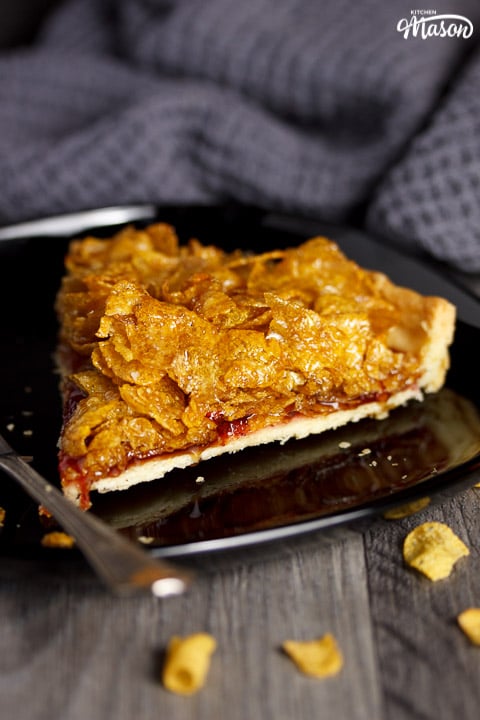 Cornflake tart slice on a plate with a fork