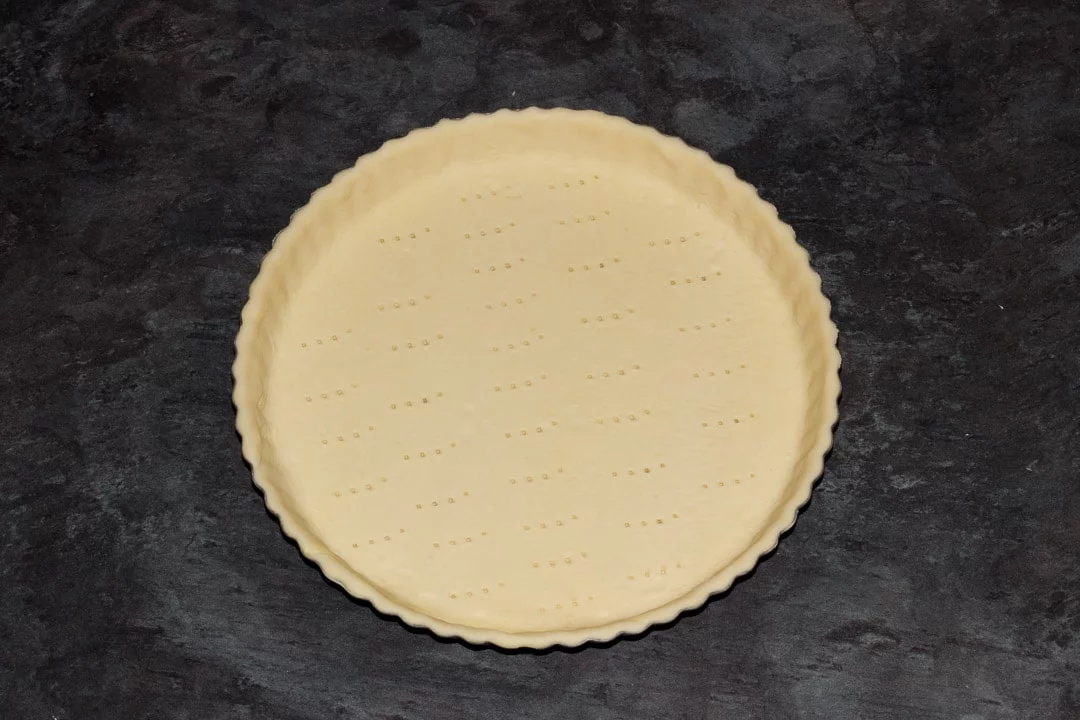a fluted tart tin lined with shortcrust pastry