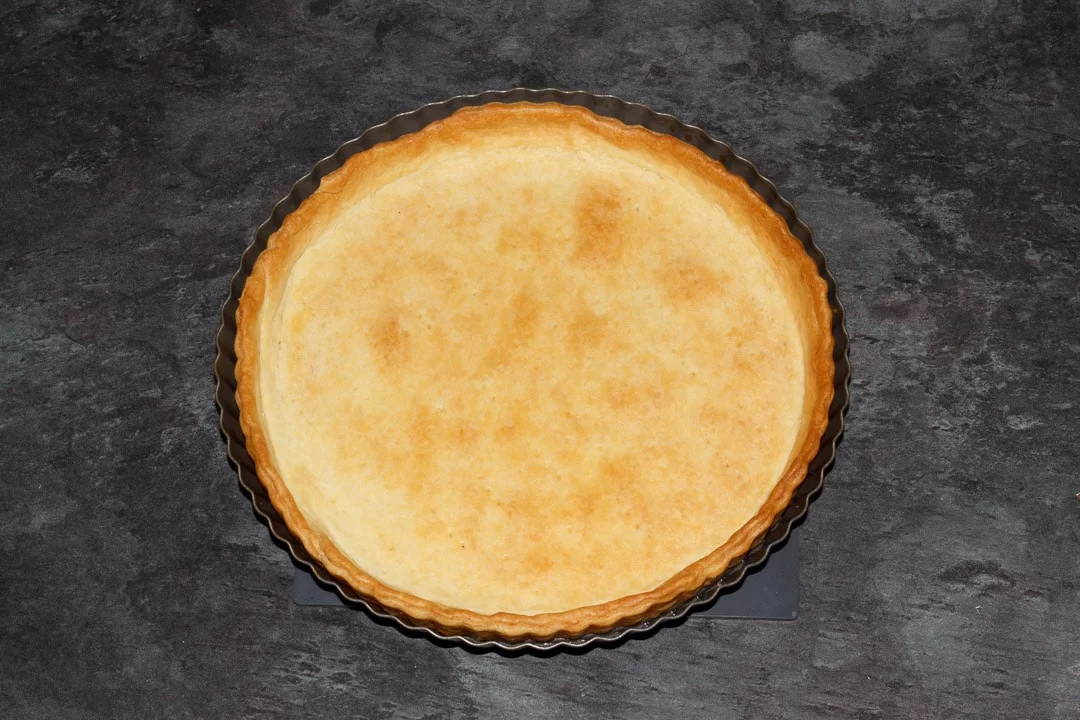 a baked shortcrust pastry case in a fluted tart tin