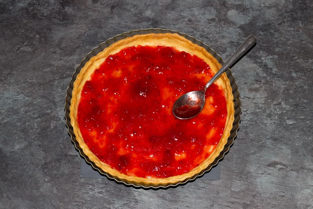 shortcrust pastry case filled with a thin layer of jam