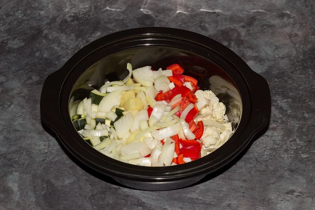 cauliflower, red pepper, onion, courgette and potato in a slow cooker bowl