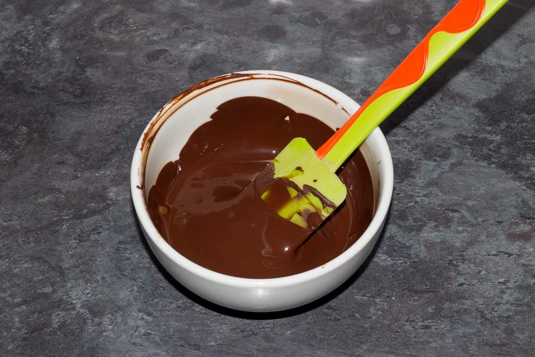 melted dark chocolate in a bowl with a spatula