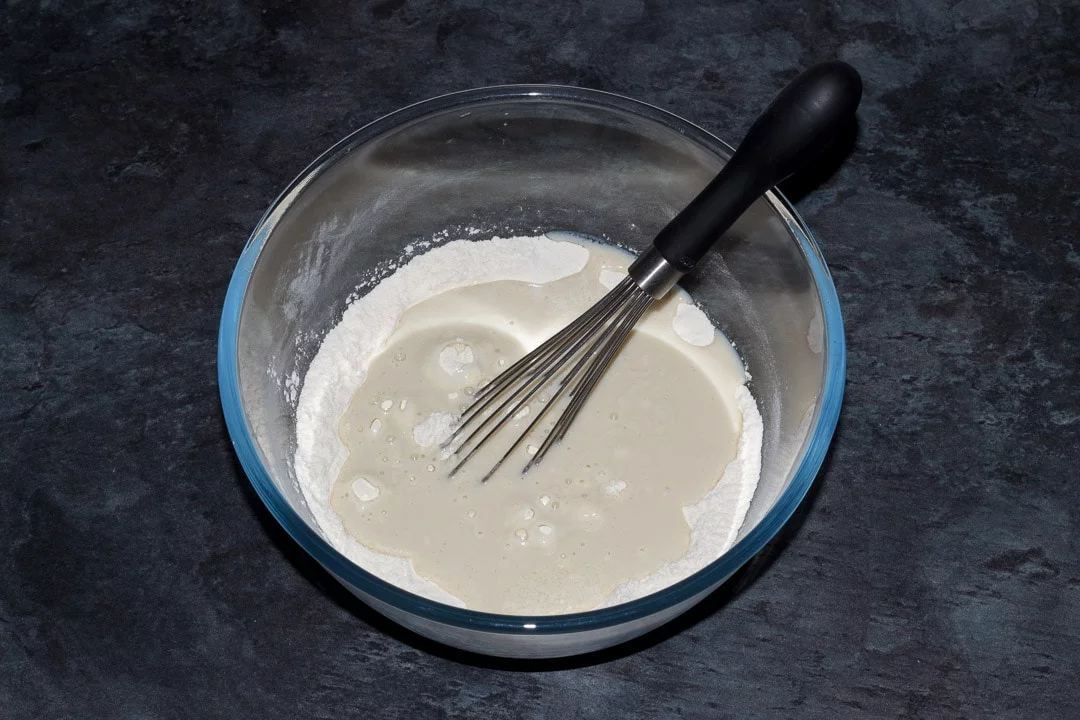 vegan pancake ingredients in a large bowl with a whisk