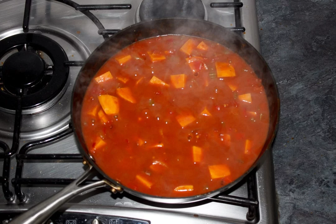 Sweet potato curry simmering in a frying pan