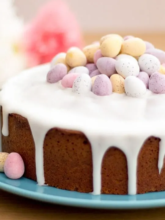 Lemon Drizzle Easter Cake on a blue plate topped with mini eggs