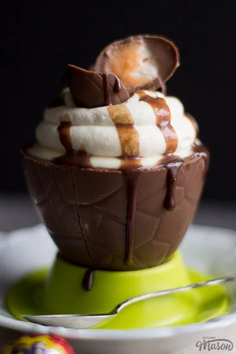 No Bake Easter Cheesecake in an Easter Egg Bowl in a green egg cup with a spoon.