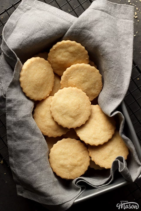 shortbread cookies in a tin lined with a grey cloth