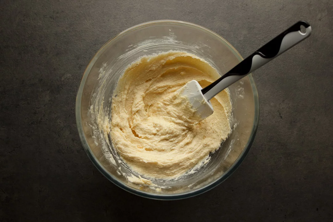 Butter, vanilla and sugar creamed together in a glass bowl