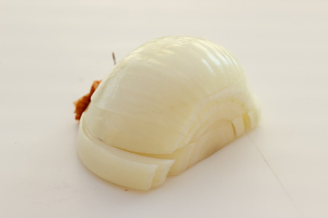 Half a peeled onion that's been sliced twice horizontally