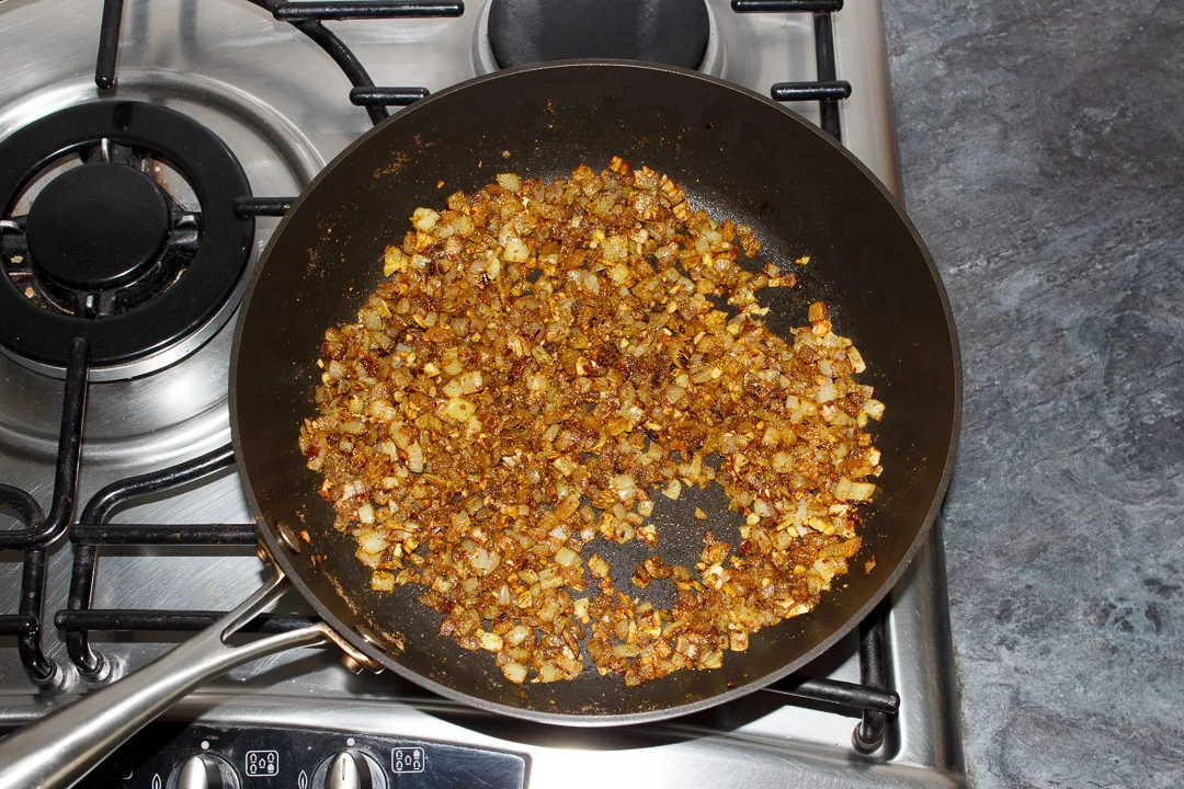 Onion, garlic, ginger, and spices frying in a pan