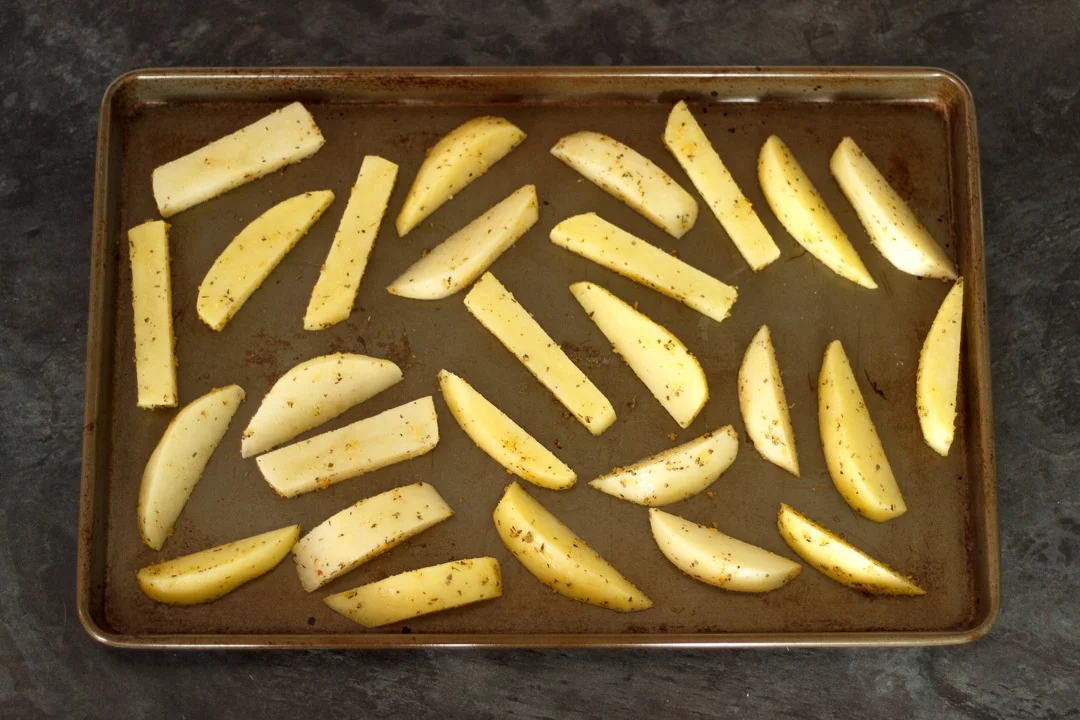 prepared potato wedges on a baking tray