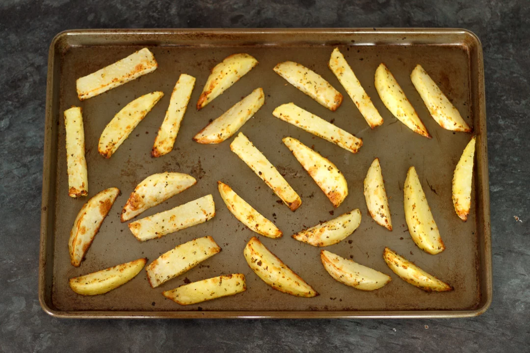 part cooked homemade wedges on a baking tray