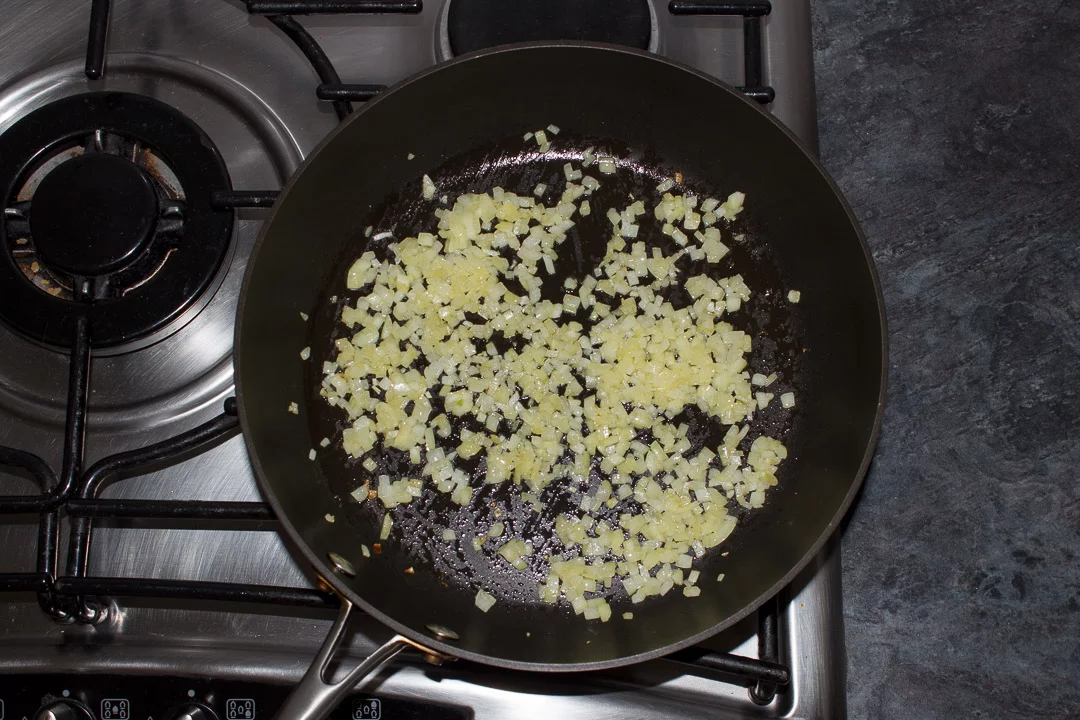 finely diced onion frying in a large saute pan