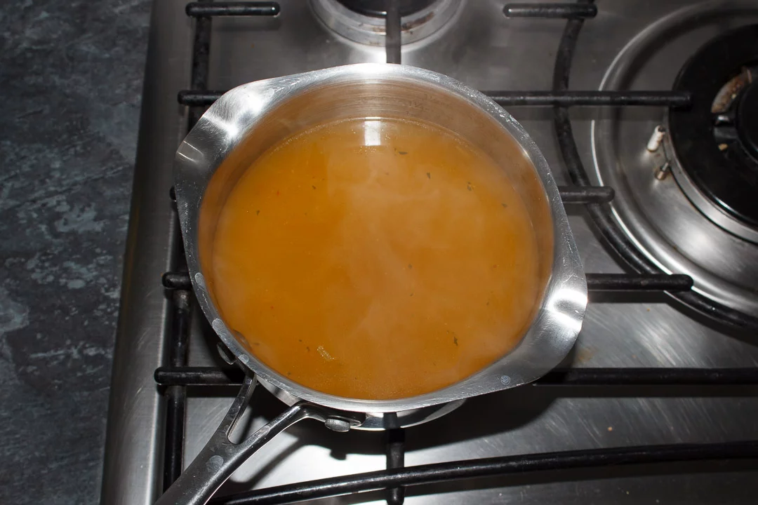 hot vegetable stock in a saucepan on the hob