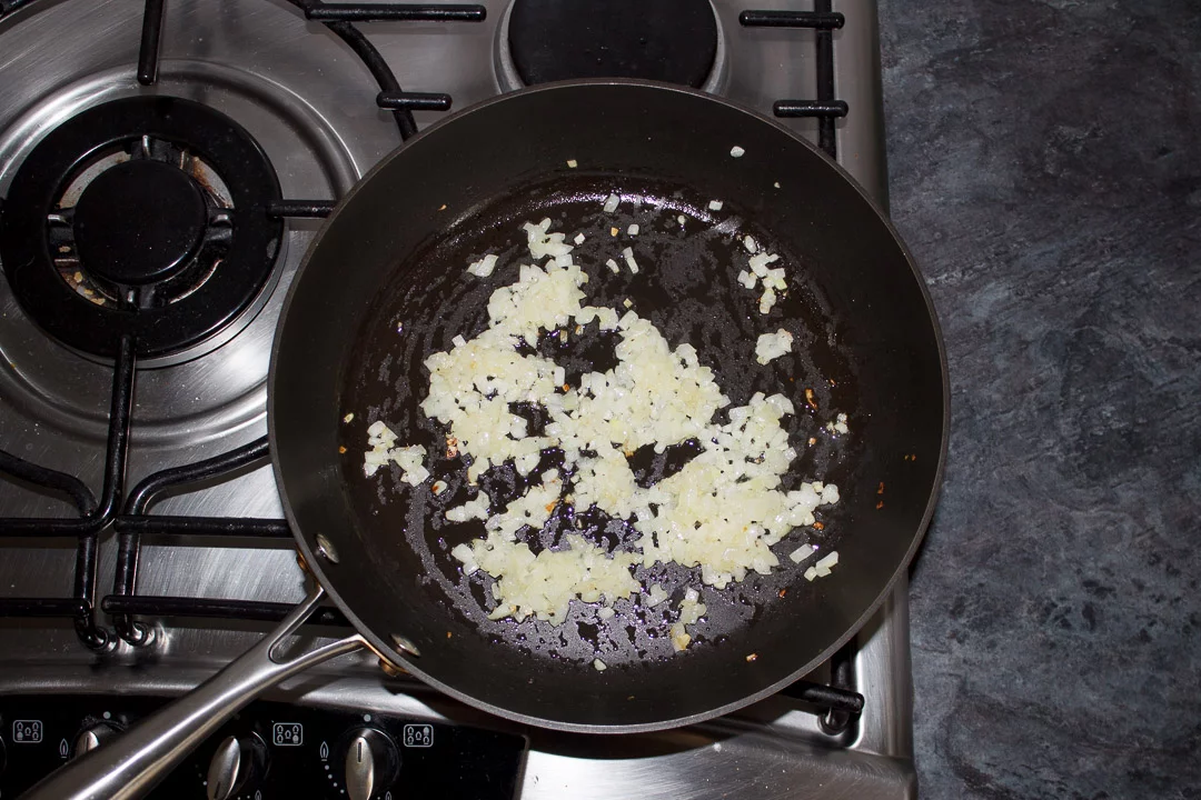 onions frying in a large saute pan