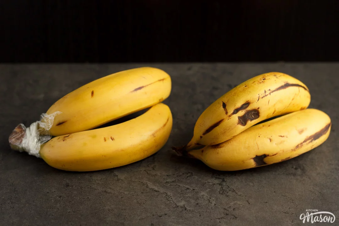 two pairs of bananas next to each other, one with the stem covered in cling film