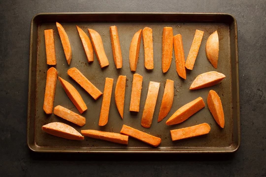 sweet potato wedges spaced out on a baking tray