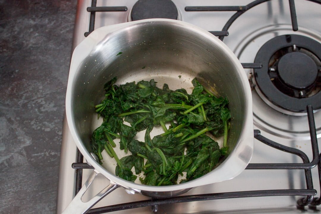 cooked garlic spinach in a saucepan