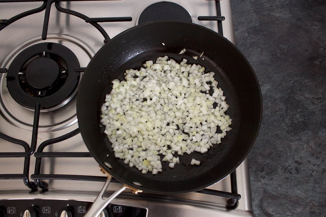 diced onion frying in a frying pan