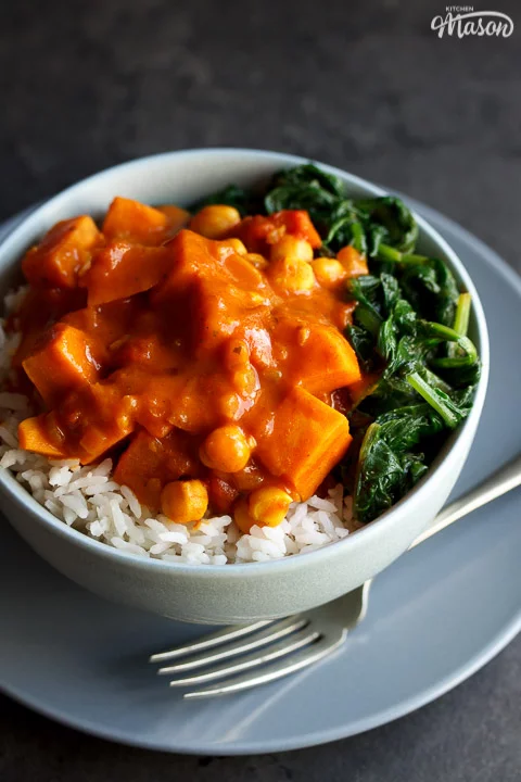 sweet potato chickpea curry in a bowl with rice and spinach