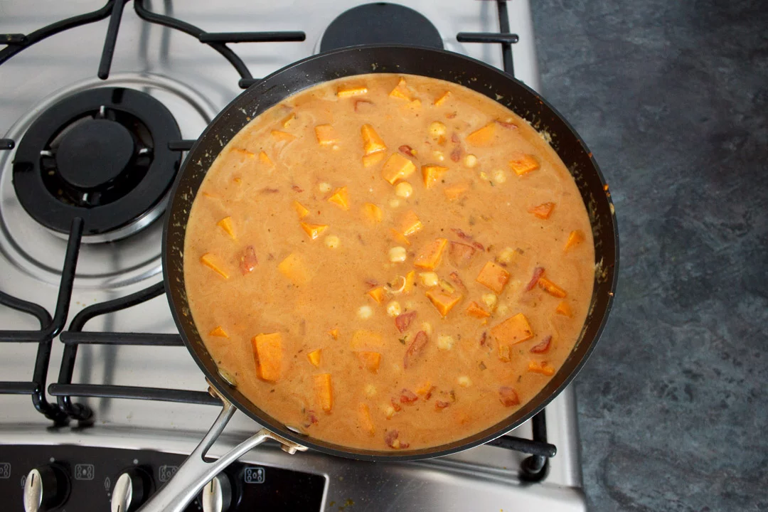 sweet potato chickpea curry coming up to the boil in a frying pan