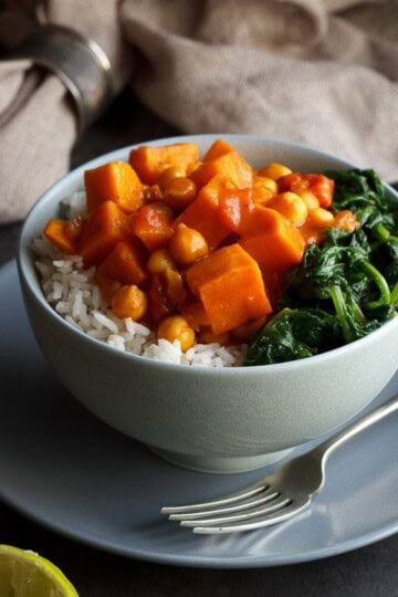 sweet potato chickpea curry in a bowl with rice and spinach