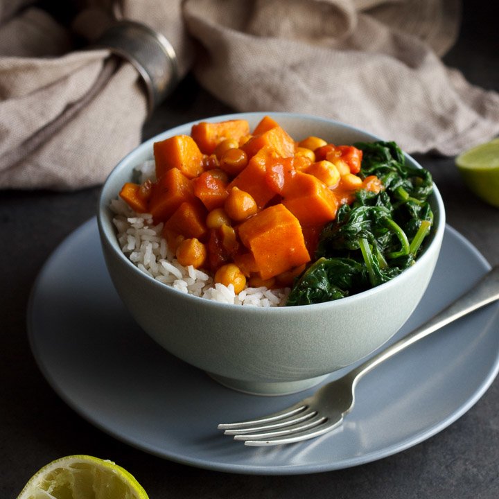 sweet potato chickpea curry in a bowl with rice and spinach