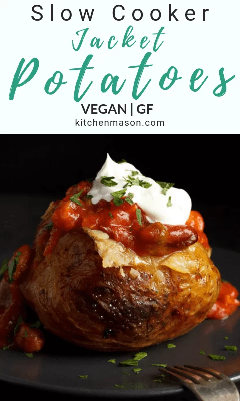 A slow cooker jacket potato on a grey plate topped with vegan chilli and vegan creme fraiche