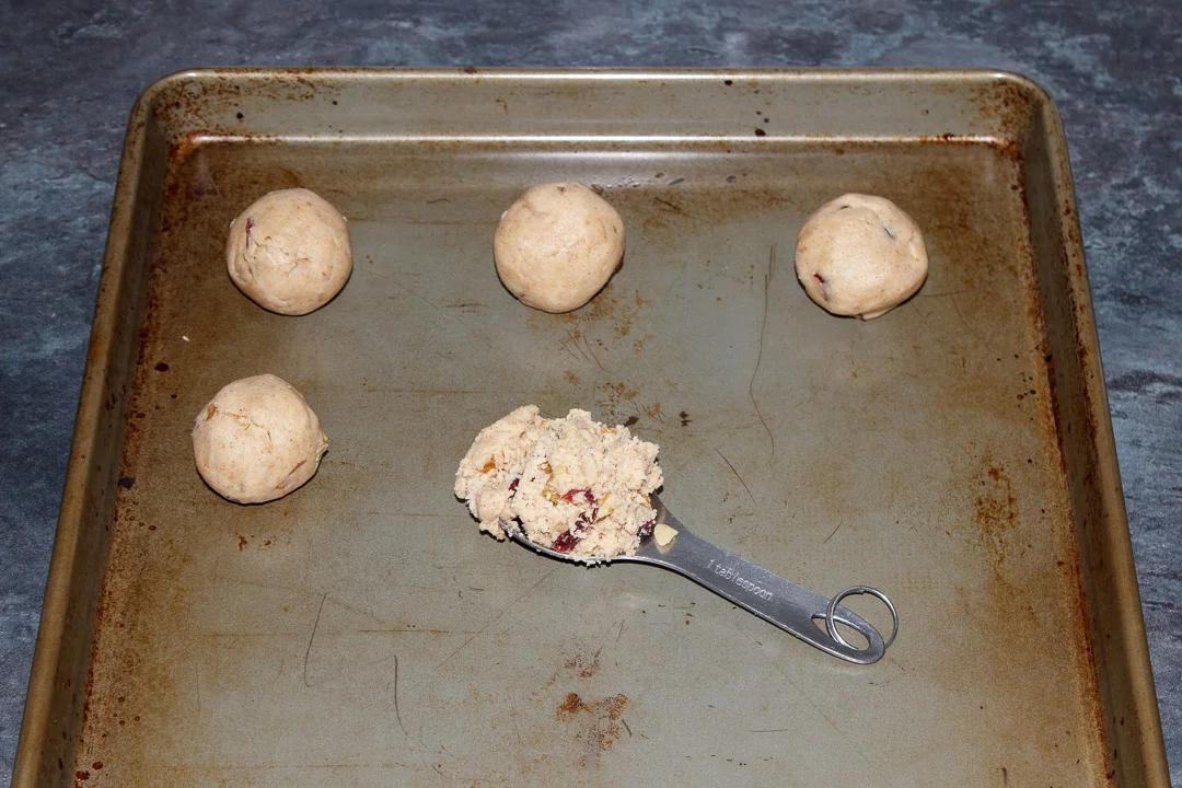Cranberry Walnut Cinnamon Cookie dough balls on a baking tray