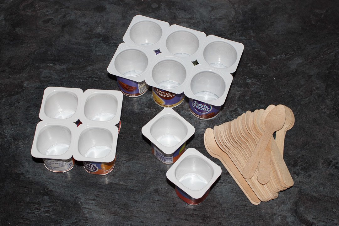 Empty petit filous yoghurt pots and small wooden teaspoons