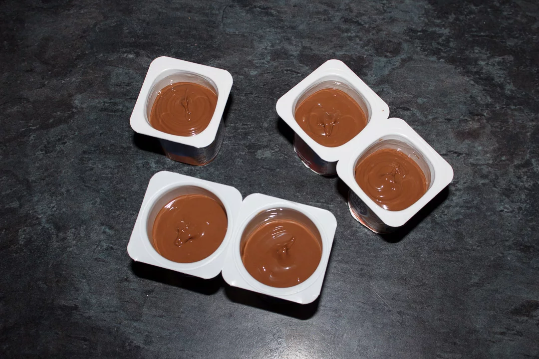 Melted milk chocolate in small yoghurt pots