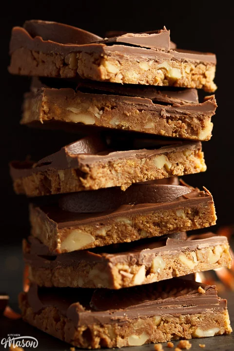 Stack of Terry's chocolate orange tiffin bars surrounded by crumbs, chocolate orange segments and curling ribbon