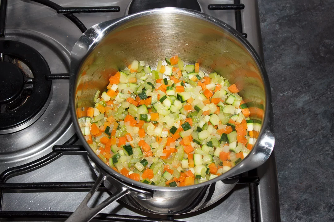 Carrot, courgette, celery and onion frying in a large saucepan