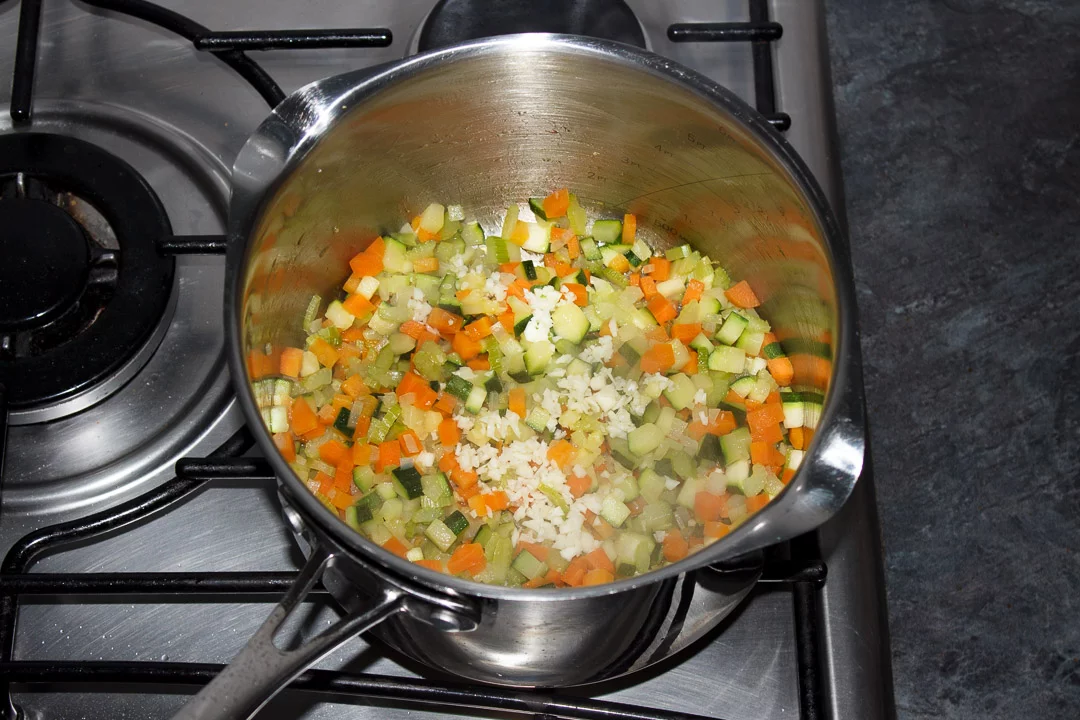 Carrot, courgette, celery, onion and garlic frying in a large saucepan