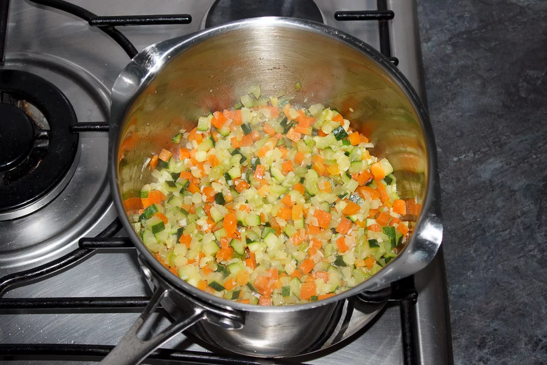 Carrot, courgette, celery, onion and garlic frying in a large saucepan