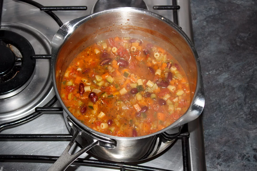 Minestrone soup simmering in a large saucepan