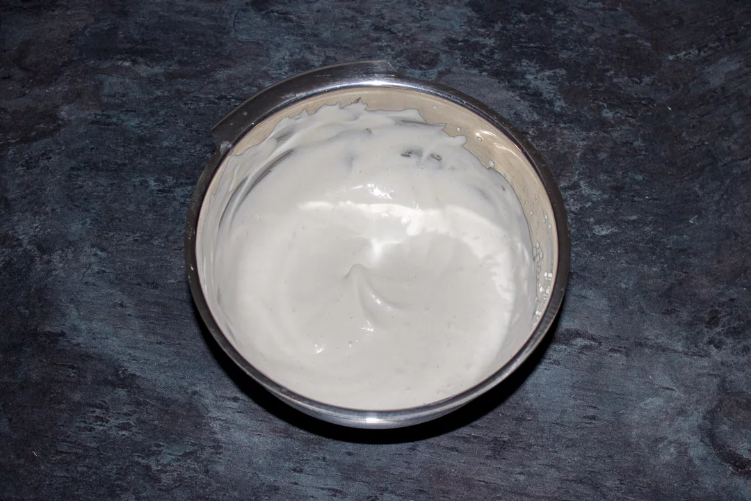 Cream whipped to soft peaks in a small metal bowl