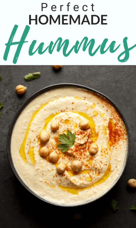 Homemade hummus in a bowl topped with chickpeas, olive oil, paprika and parsley