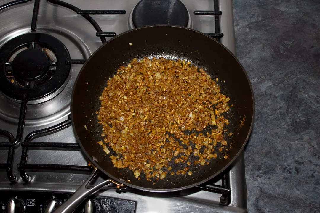 Onion, garlic and ginger frying in a pan with spices