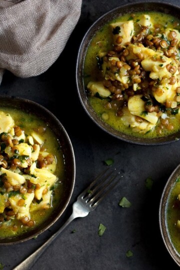 3 bowls of Fish curry with a couple of forks and a cloth