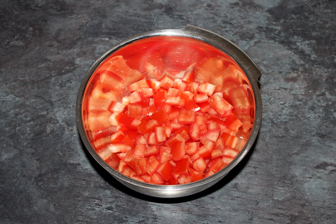 Diced desseded tomato in a silver bowl
