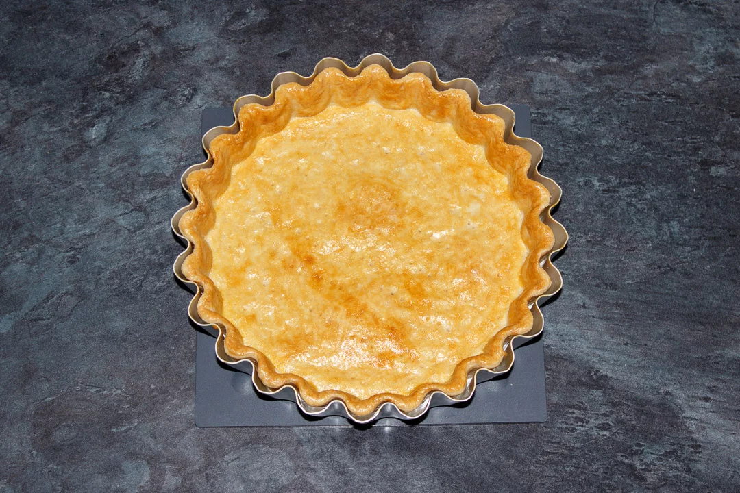 A baked shortcrust pastry case in a tart tin