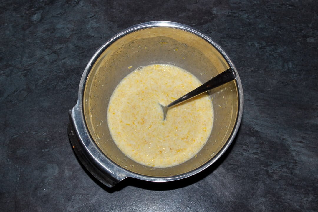 Lemon juice, lemon zest and cornflour mixed together in a metal bowl with a spoon