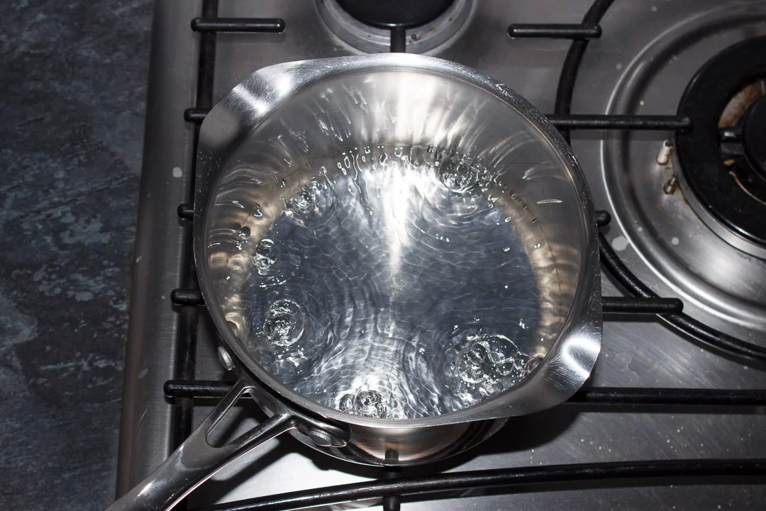 Water boiling in a saucepan set over a medium heat
