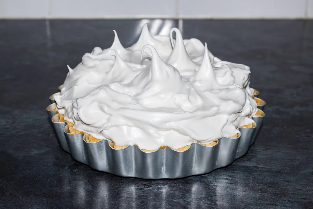 Meringue roughly spooned on top of a lemon meringue pie before being baked